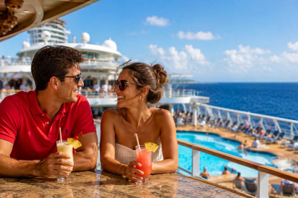 Young couple relaxing with tropical drinks on a seven-day cruise from Galveston